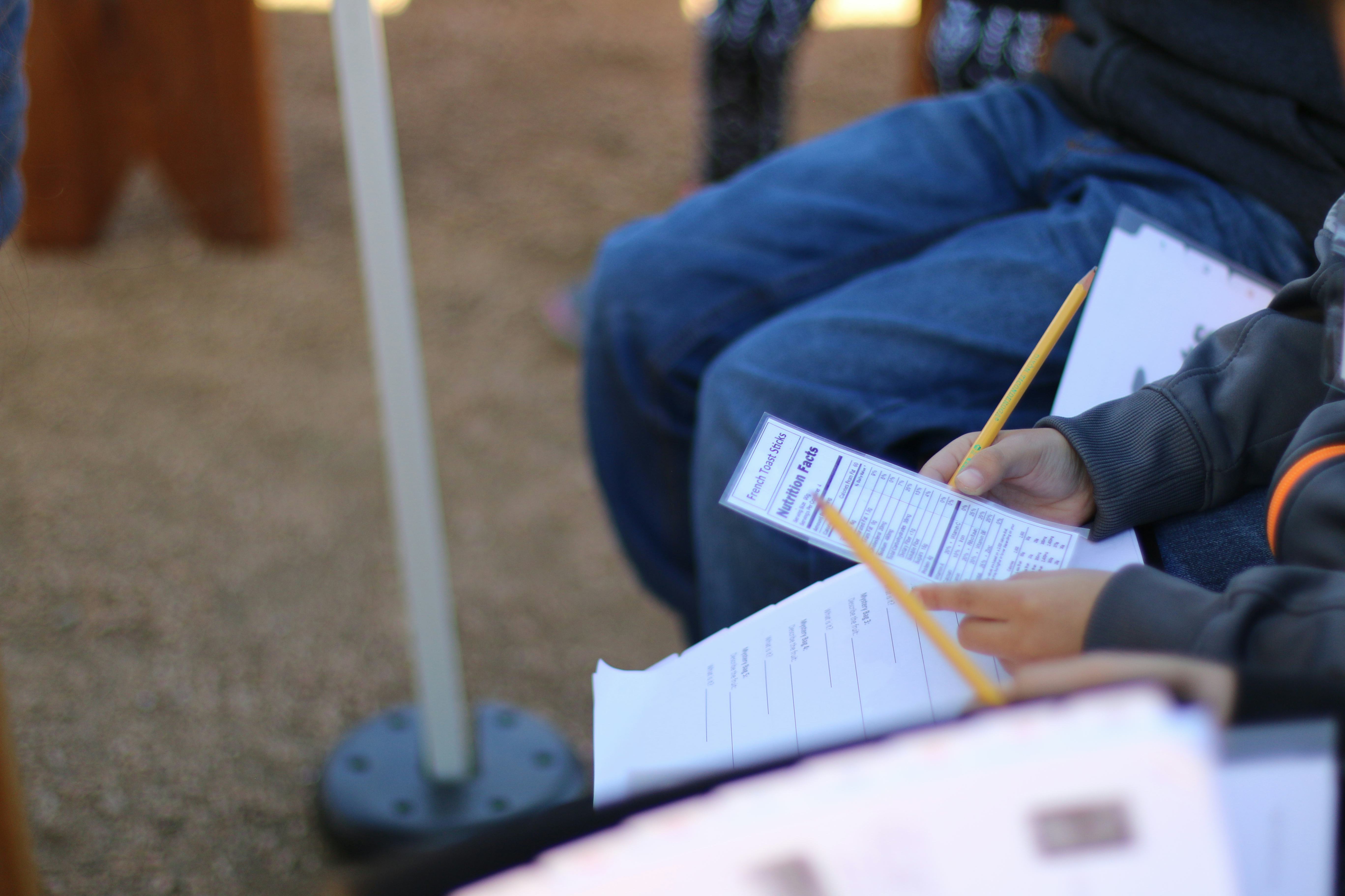 Elementary-aged student holding a printout of a nutrition label.